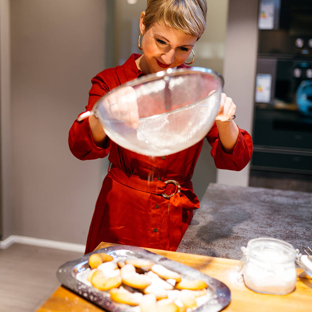 Silke Walner bestreut Plätzchen mit Puderzucker