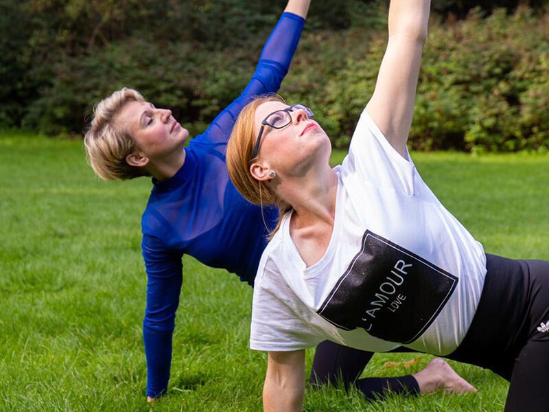 Partner-Yoga auf der Wiese